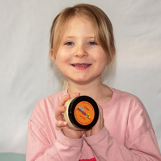 Young girl holding a container of Star Essence Cheer Therapy Putty against a plain background