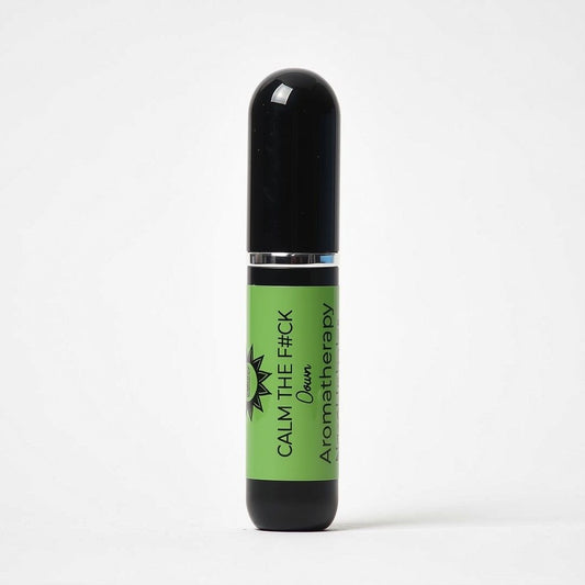 An aromatherapy nasal inhaler of Calm the F*ck Down aromatherapy blend featuring a black cap and base with a bright green label, set against a plain white background.