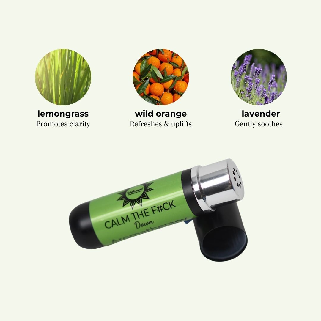 A green and black aroma inhaler labeled 'CALM THE F*CK Down' with lavender and citrus imagery above, on a light cream background.