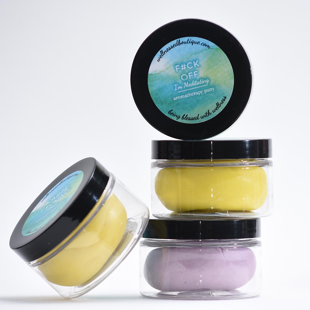 Three small jars with black lids containing I'm Meditating Sensory Putty on a white background