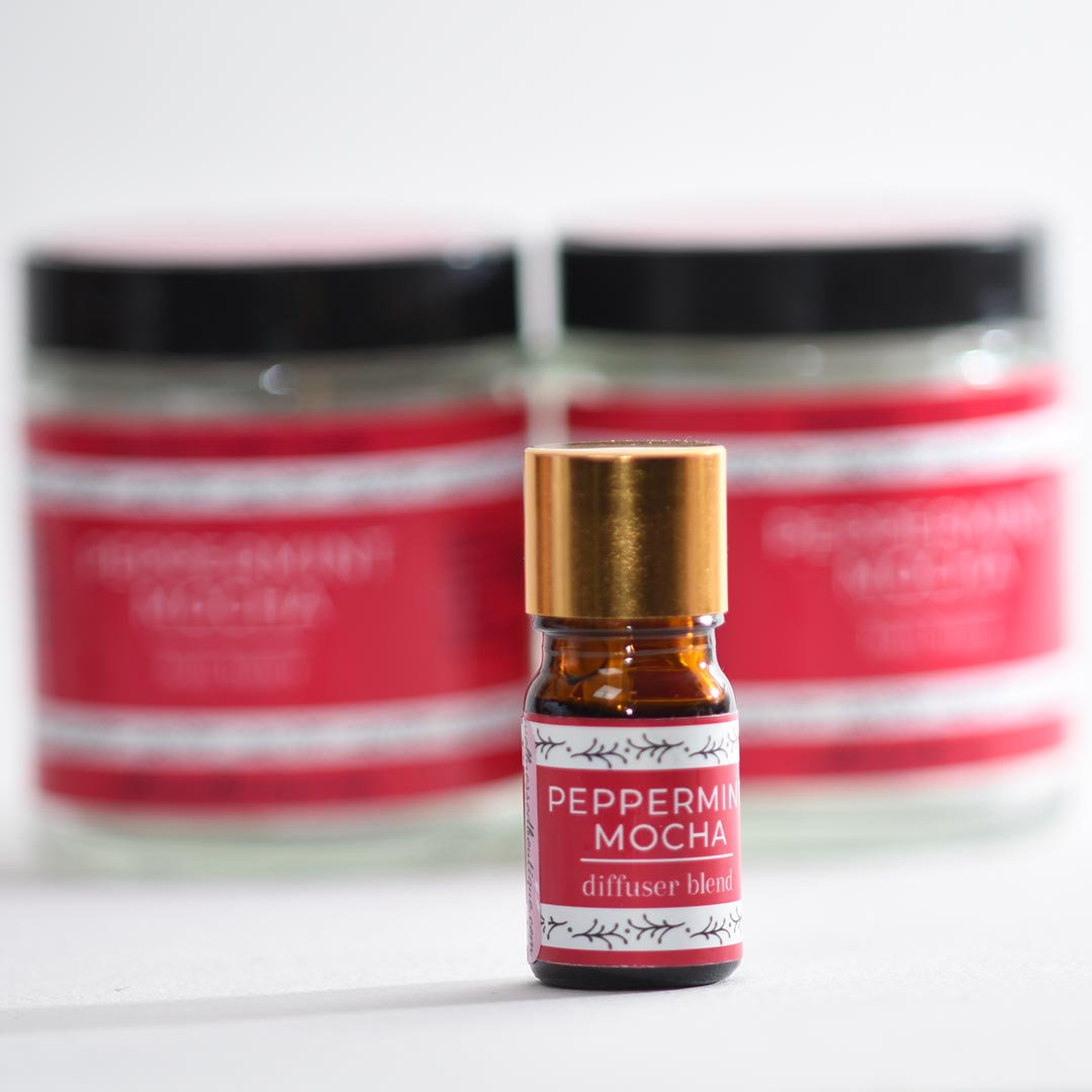 Small bottle of peppermint mocha diffuser blend with two peppermint mocha body butter jars in the background