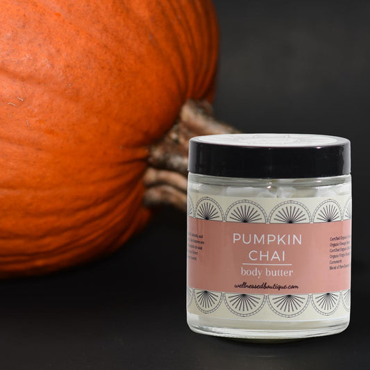 Jar of pumpkin chai body butter with a pumpkin in the background