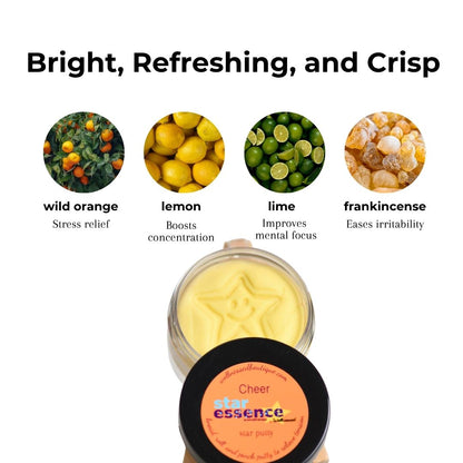 A jar of Cheer Star Essence sensory putty shown with its lid in front, on a white background with text and ingredient icons for wild orange, lemon, lime, and frankincense.