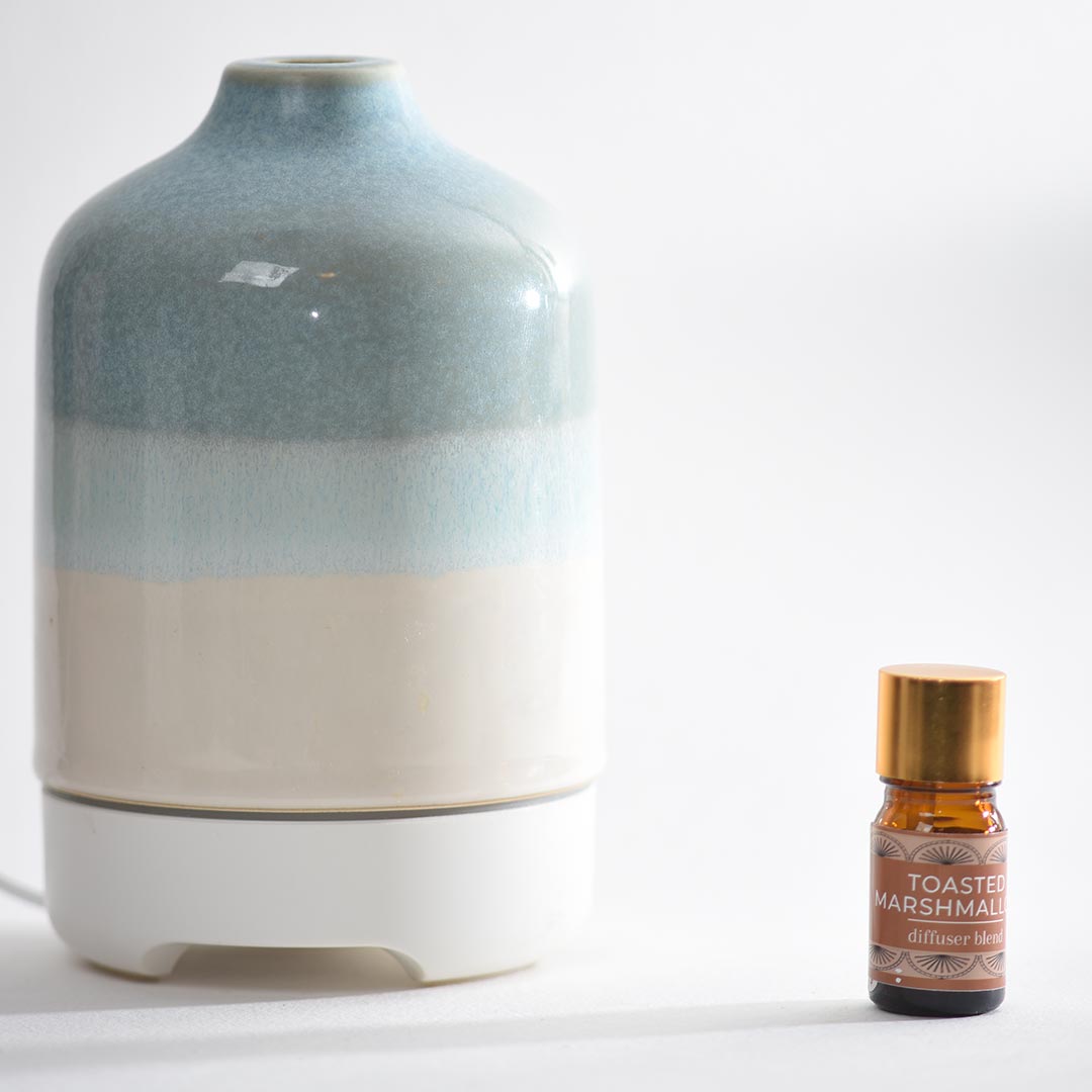Decorative diffuser and bottle of 'Toasted Marshmallow' essential oil on a white background